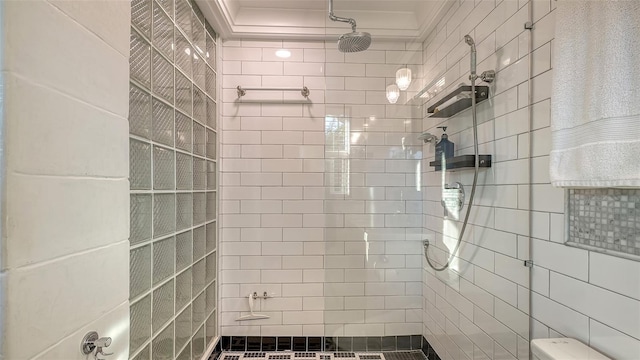 bathroom featuring ornamental molding and a tile shower