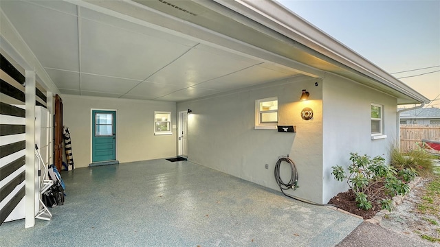 garage with an attached carport and fence