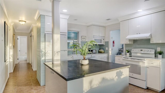 kitchen featuring crown molding, tasteful backsplash, white cabinets, white appliances, and under cabinet range hood