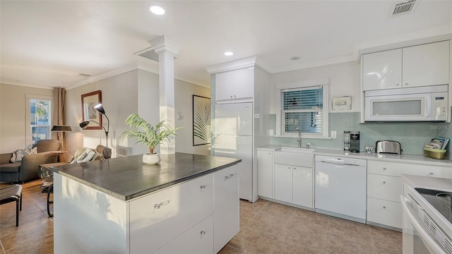 kitchen featuring visible vents, decorative backsplash, a sink, white appliances, and ornate columns