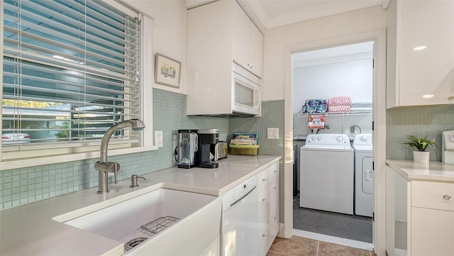 washroom with laundry area, separate washer and dryer, a sink, and tile patterned floors