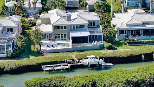 rear view of house with a water view, a residential view, and stucco siding