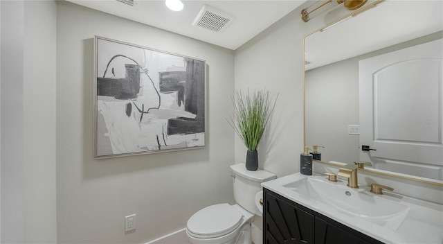 half bath featuring toilet, vanity, and baseboards