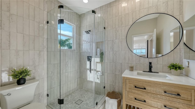 full bath featuring tile walls, toilet, a shower stall, and vanity