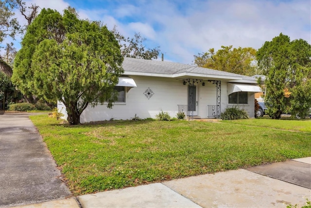 view of front of property featuring a shingled roof and a front yard