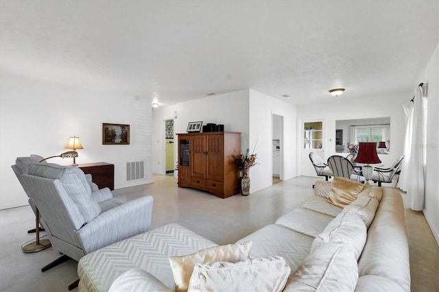 living area featuring finished concrete flooring and visible vents