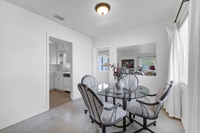 dining area with visible vents, finished concrete flooring, and a textured ceiling