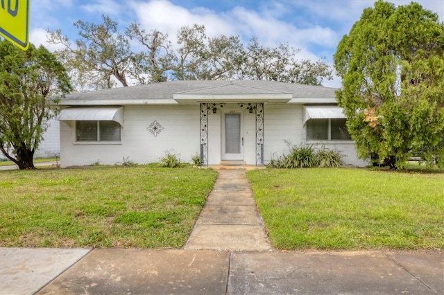 ranch-style house with roof with shingles and a front yard