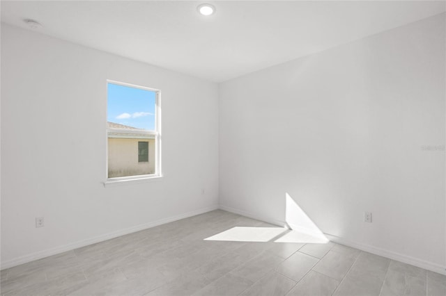 unfurnished room with baseboards