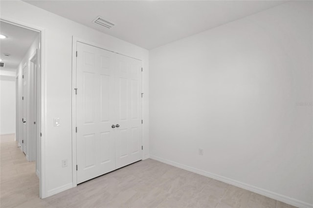 unfurnished bedroom featuring a closet, visible vents, and baseboards