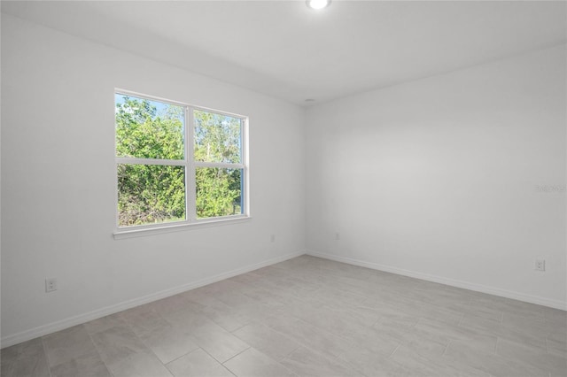 unfurnished room featuring baseboards