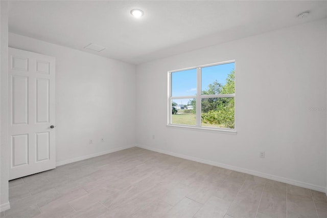 unfurnished room with baseboards