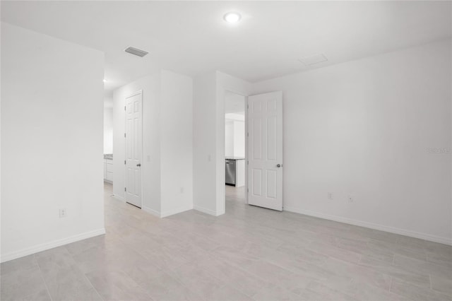 unfurnished room with visible vents and baseboards