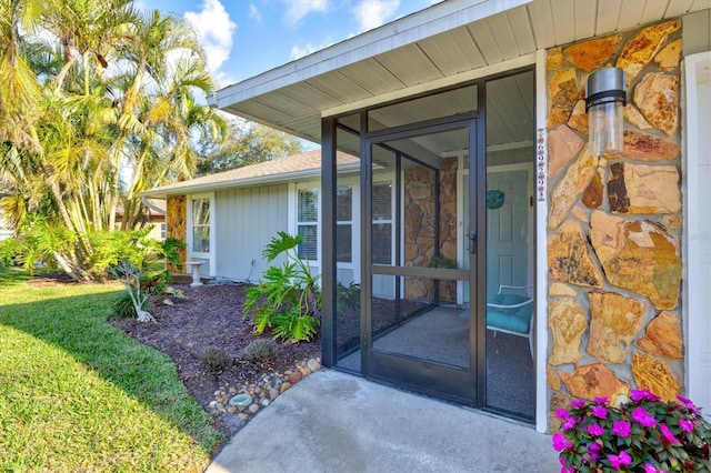 view of exterior entry featuring a lawn