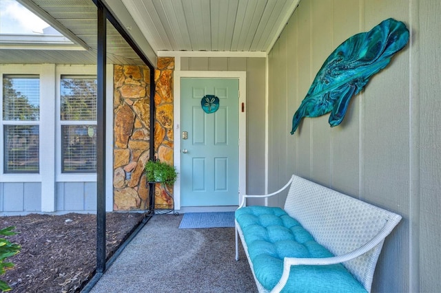 property entrance featuring board and batten siding and stone siding