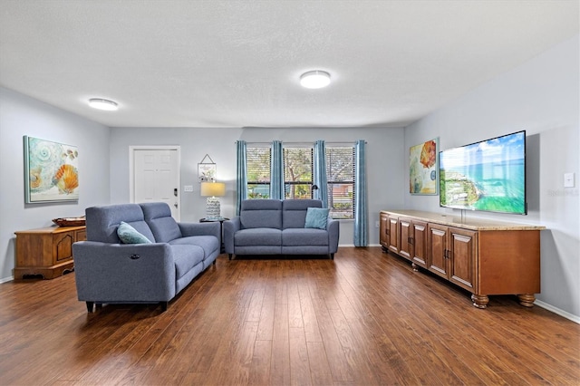 living room with dark wood-type flooring, a textured ceiling, and baseboards