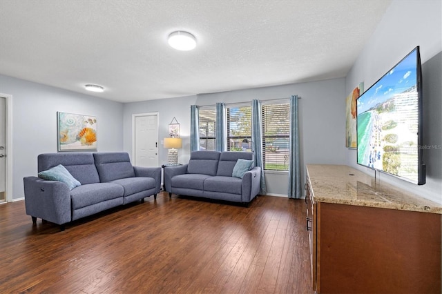 living area with dark wood-style floors, a textured ceiling, and baseboards