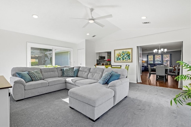 living room featuring lofted ceiling, visible vents, dark carpet, and ceiling fan with notable chandelier