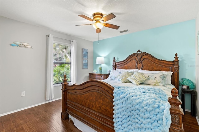 bedroom with visible vents, dark wood-type flooring, ceiling fan, a textured ceiling, and baseboards