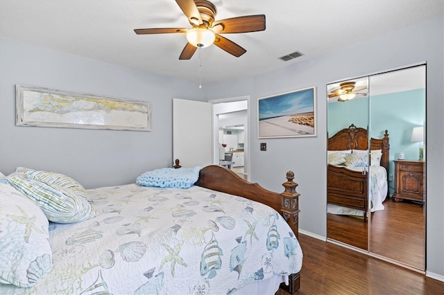 bedroom featuring dark wood-style floors, ceiling fan, visible vents, and baseboards