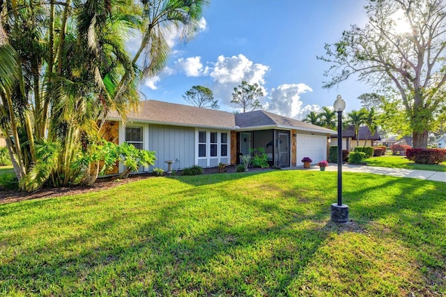 single story home featuring a garage, a front yard, driveway, and board and batten siding