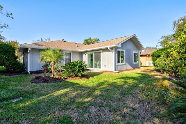 back of house featuring fence and a lawn