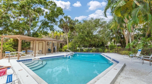 pool with a patio area and fence