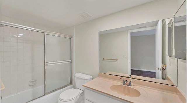 bathroom with toilet, visible vents, bath / shower combo with glass door, and vanity