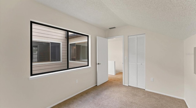 unfurnished bedroom with baseboards, visible vents, carpet, a textured ceiling, and a closet