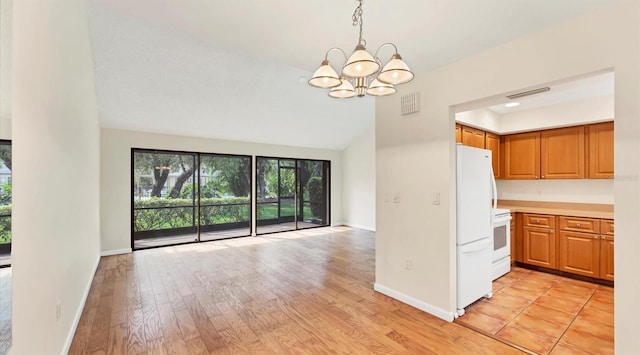 kitchen with white appliances, baseboards, open floor plan, and light wood finished floors