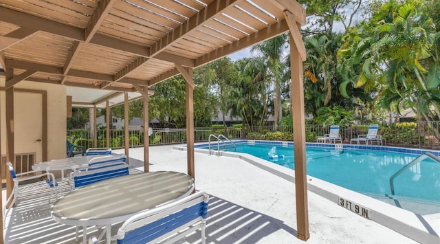 community pool featuring outdoor dining area, a patio area, and a fenced backyard