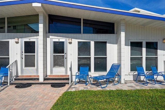 view of exterior entry with a patio