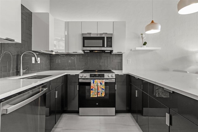 kitchen with white cabinets, hanging light fixtures, stainless steel appliances, dark cabinetry, and a sink