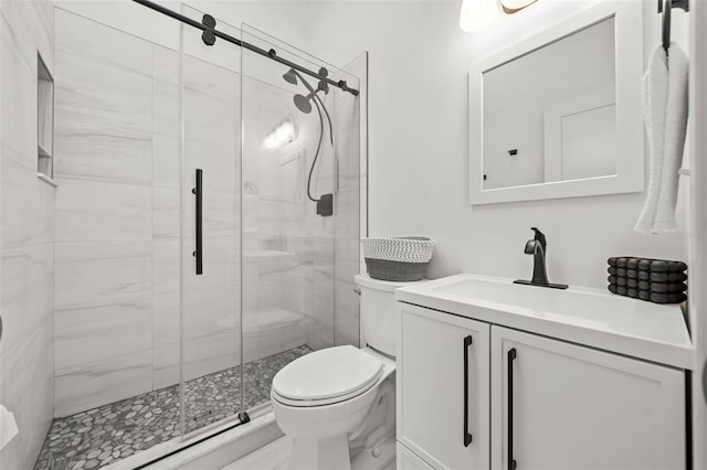 bathroom featuring toilet, a stall shower, and vanity