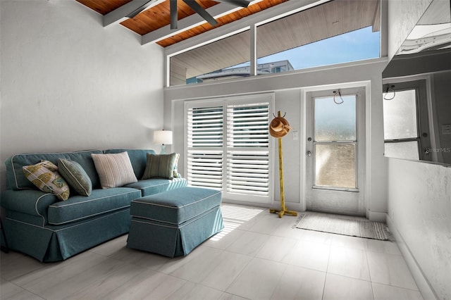 living room featuring beamed ceiling, plenty of natural light, wood ceiling, and baseboards