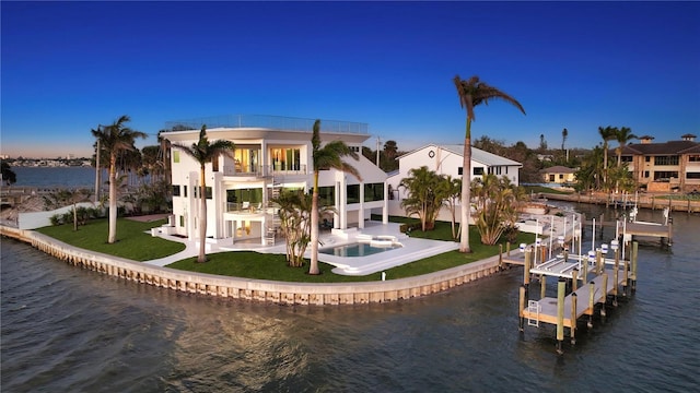 rear view of house featuring a yard, a patio, a water view, a balcony, and an in ground hot tub