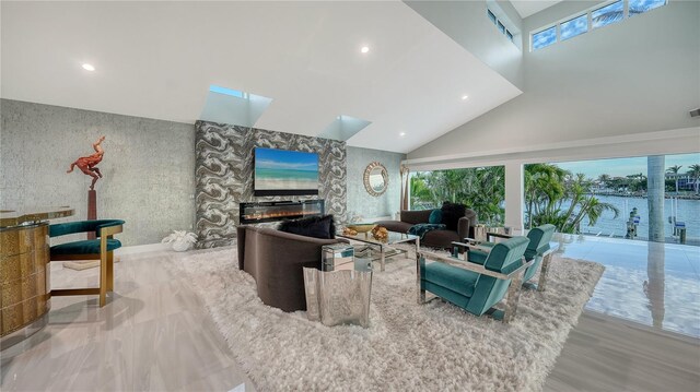 living room featuring a skylight, a fireplace, recessed lighting, high vaulted ceiling, and wallpapered walls