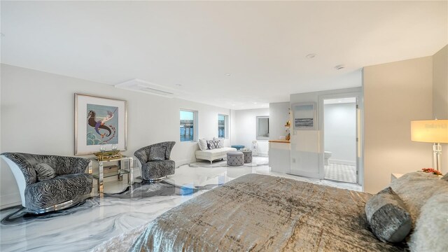 bedroom featuring marble finish floor and connected bathroom