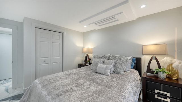 bedroom with marble finish floor, a closet, and recessed lighting