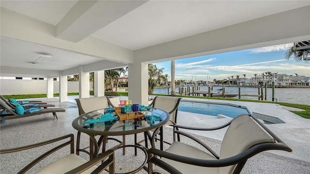 interior space with outdoor dining area, a patio area, a boat dock, and a water view