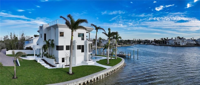 exterior space featuring a lawn and a water view