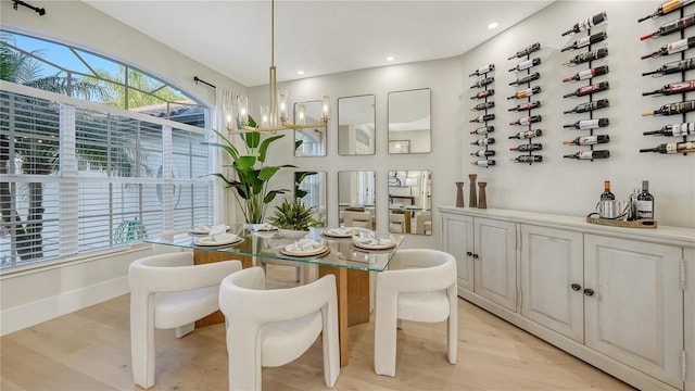 dining area with an inviting chandelier, baseboards, light wood finished floors, and recessed lighting