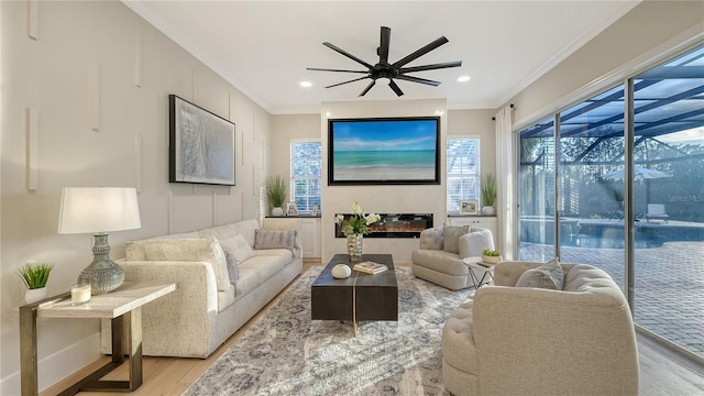 living room featuring ornamental molding, wood finished floors, a ceiling fan, and recessed lighting