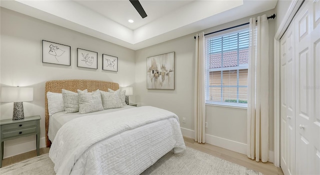 bedroom featuring light wood-type flooring, baseboards, a closet, and recessed lighting