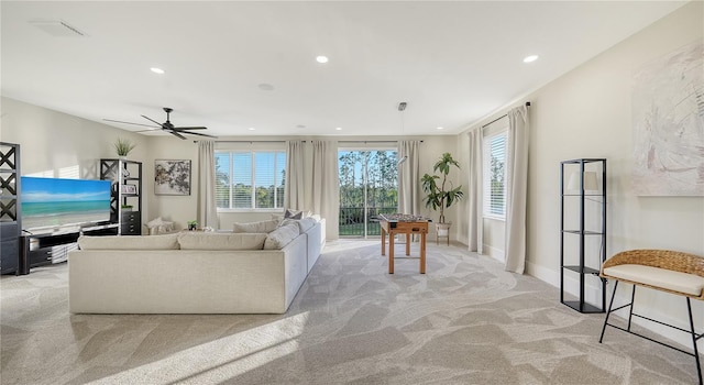 living area with recessed lighting, a healthy amount of sunlight, light carpet, and baseboards