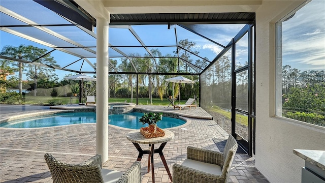 view of pool featuring a lanai, a pool with connected hot tub, and a patio