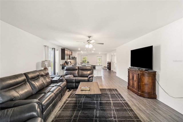 living room with wood finished floors and a ceiling fan