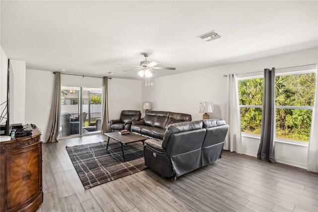 living room with a healthy amount of sunlight, a ceiling fan, visible vents, and wood finished floors