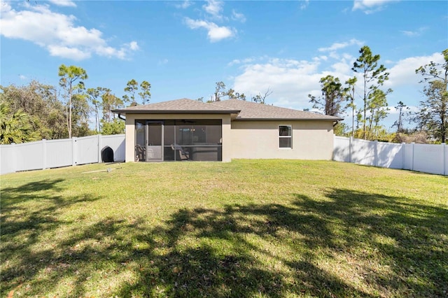 rear view of property featuring a yard, a fenced backyard, a sunroom, and stucco siding