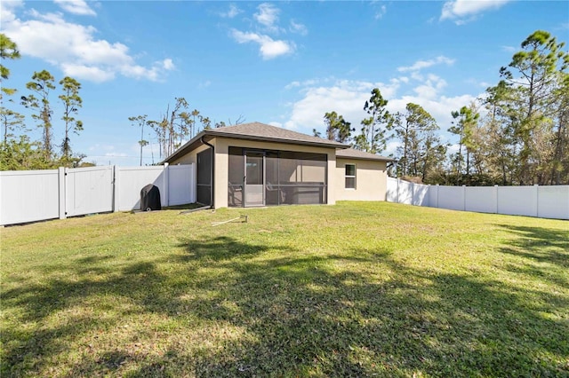 rear view of property with a fenced backyard and a yard